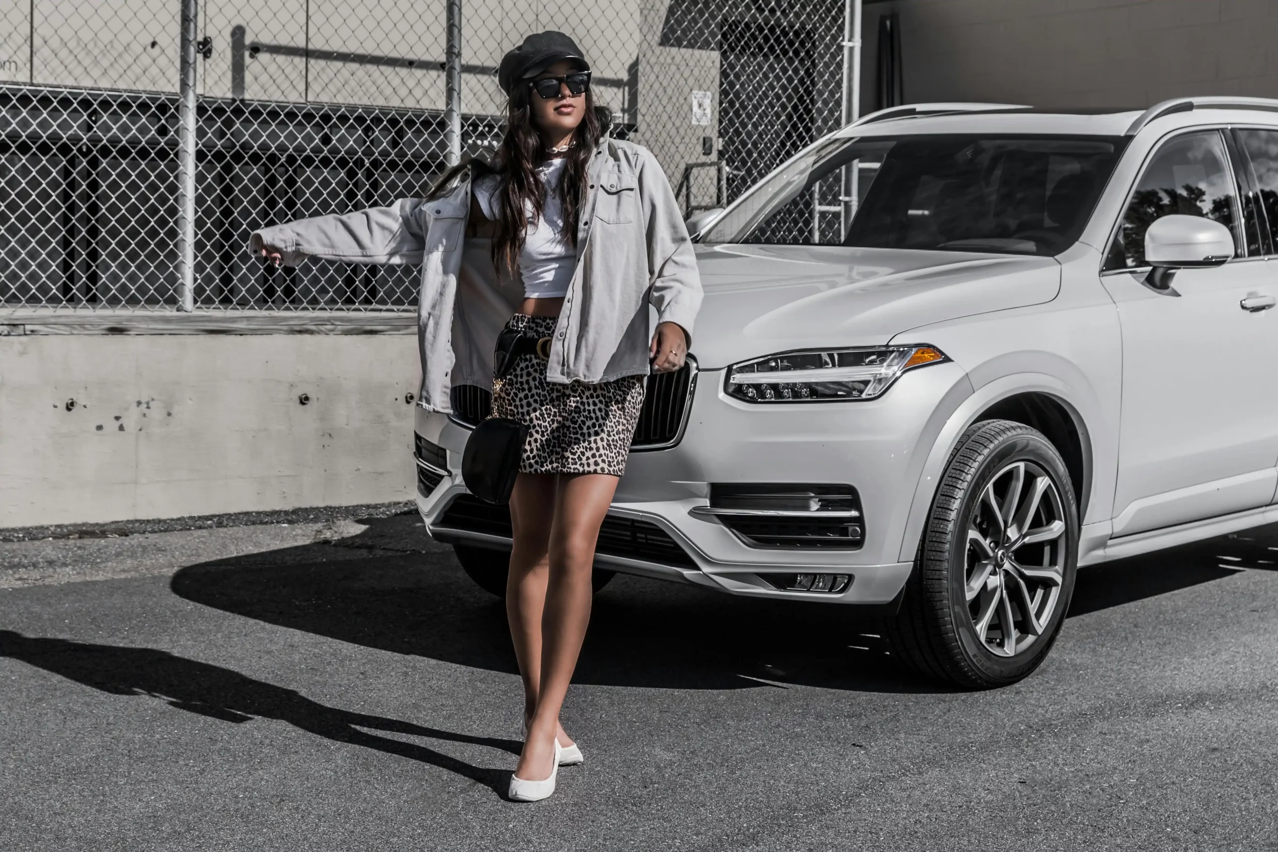 affluent business traveler with carry-on stepping from a luxury SUV onto the tarmac-side entrance of a private terminal at Boeing Field, Seattle skyline and private jet beyond