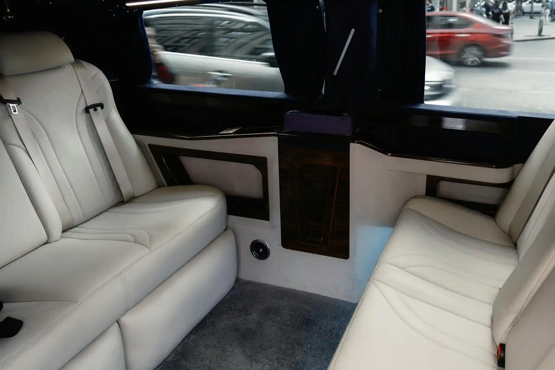 luxury limousine interior with cream leather seating, ambient LED lighting, champagne flutes, and Seattle skyline visible through tinted windows at sunset