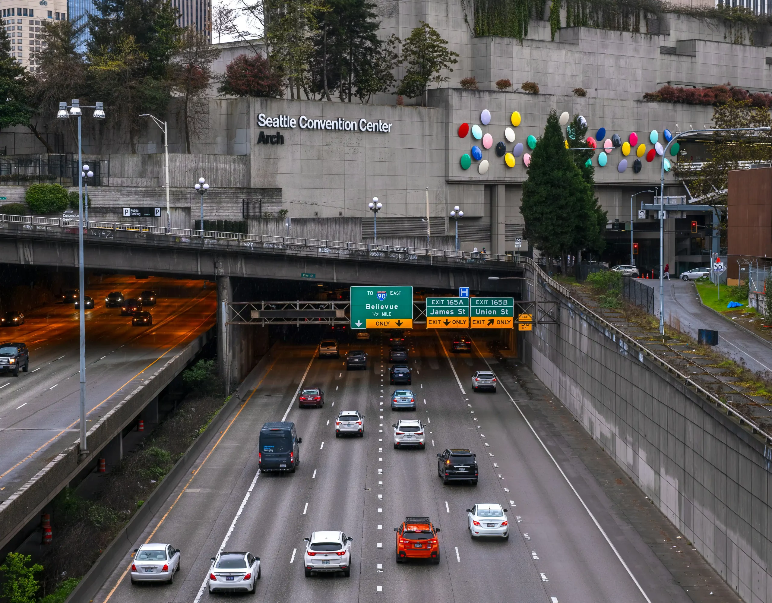 dispatch office with multiple monitors showing Seattle traffic maps, flight arrival boards, and chauffeur schedules, professional team coordinating luxury transportation