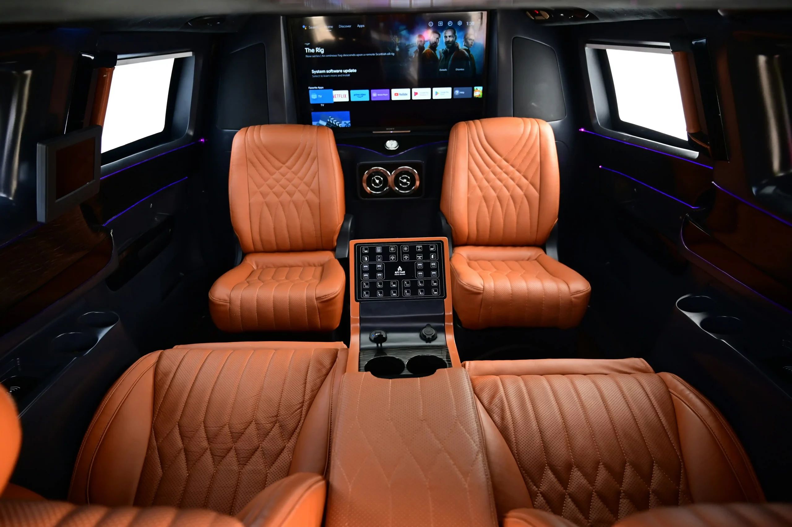 elegant interior of a black stretch limousine with ambient lighting, leather seating, bottled water, and Seattle skyline visible through tinted windows