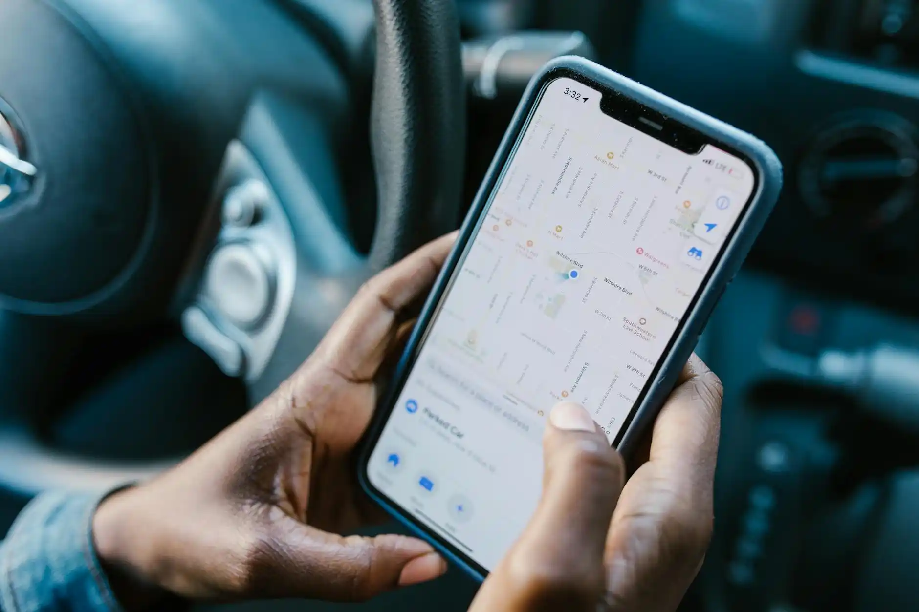 close-up of a traveler booking a luxury car ride on a smartphone in a stylish Seattle hotel lobby, black luggage, raincoat, and city map on a marble table